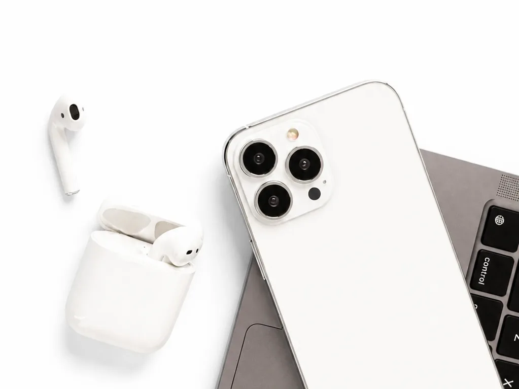 iPhone, AirPods y portátil sobre fondo blanco